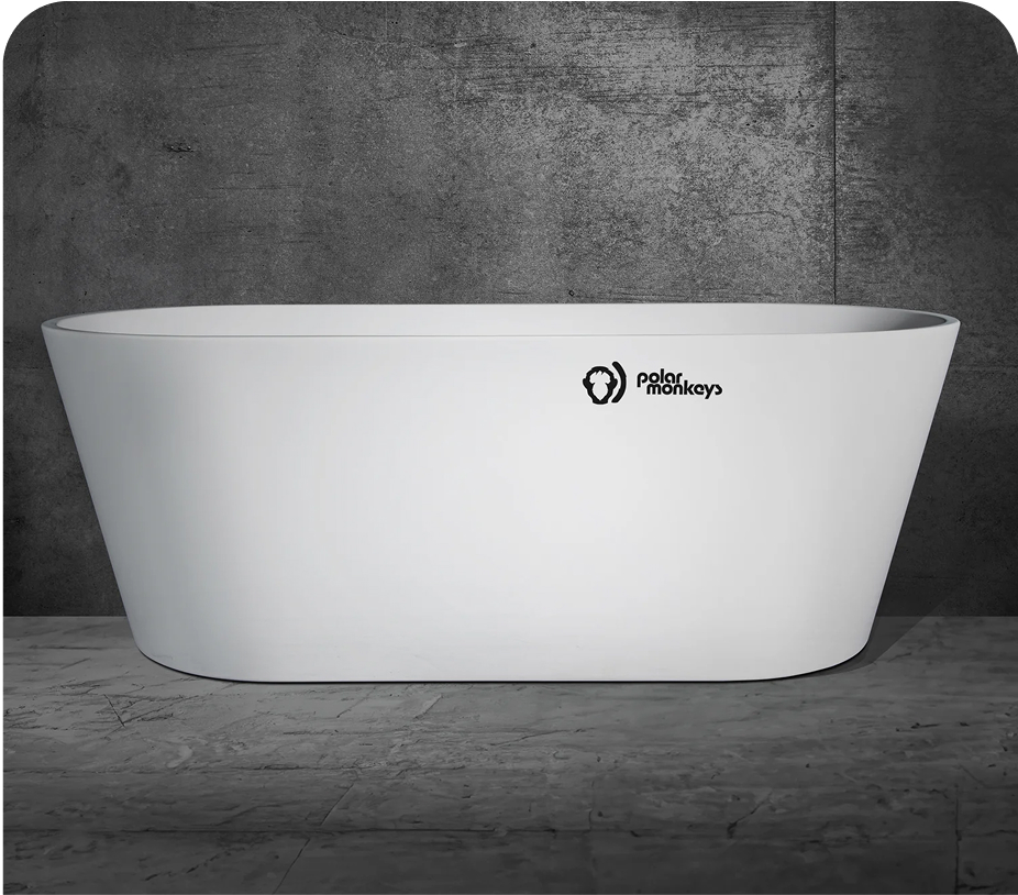 Modern white bathtub with 'Polar Monkeys' logo against a gray stone wall.