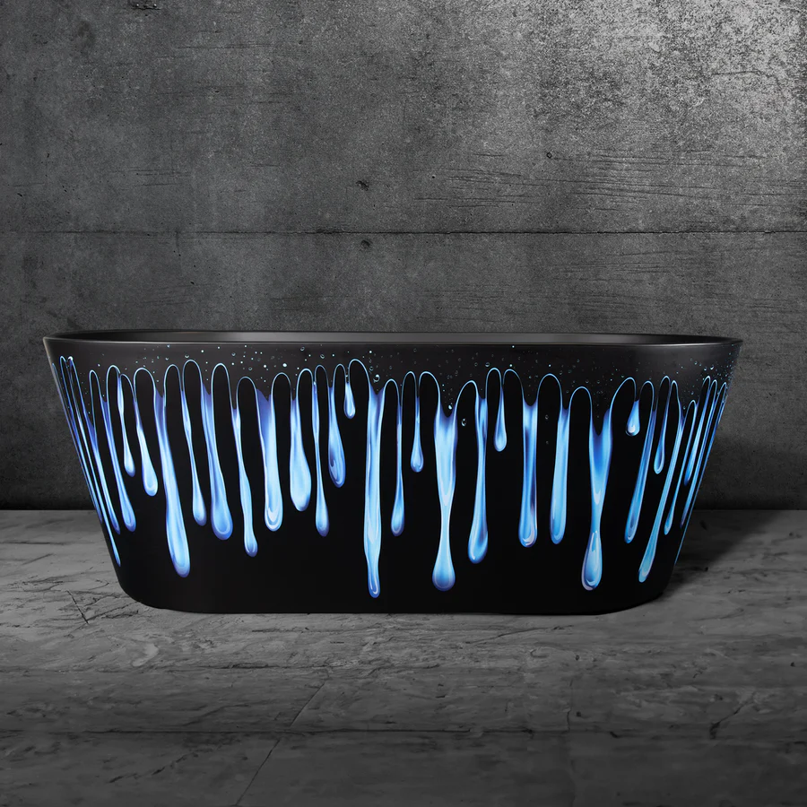 Black bathtub with blue drip design against a concrete wall.