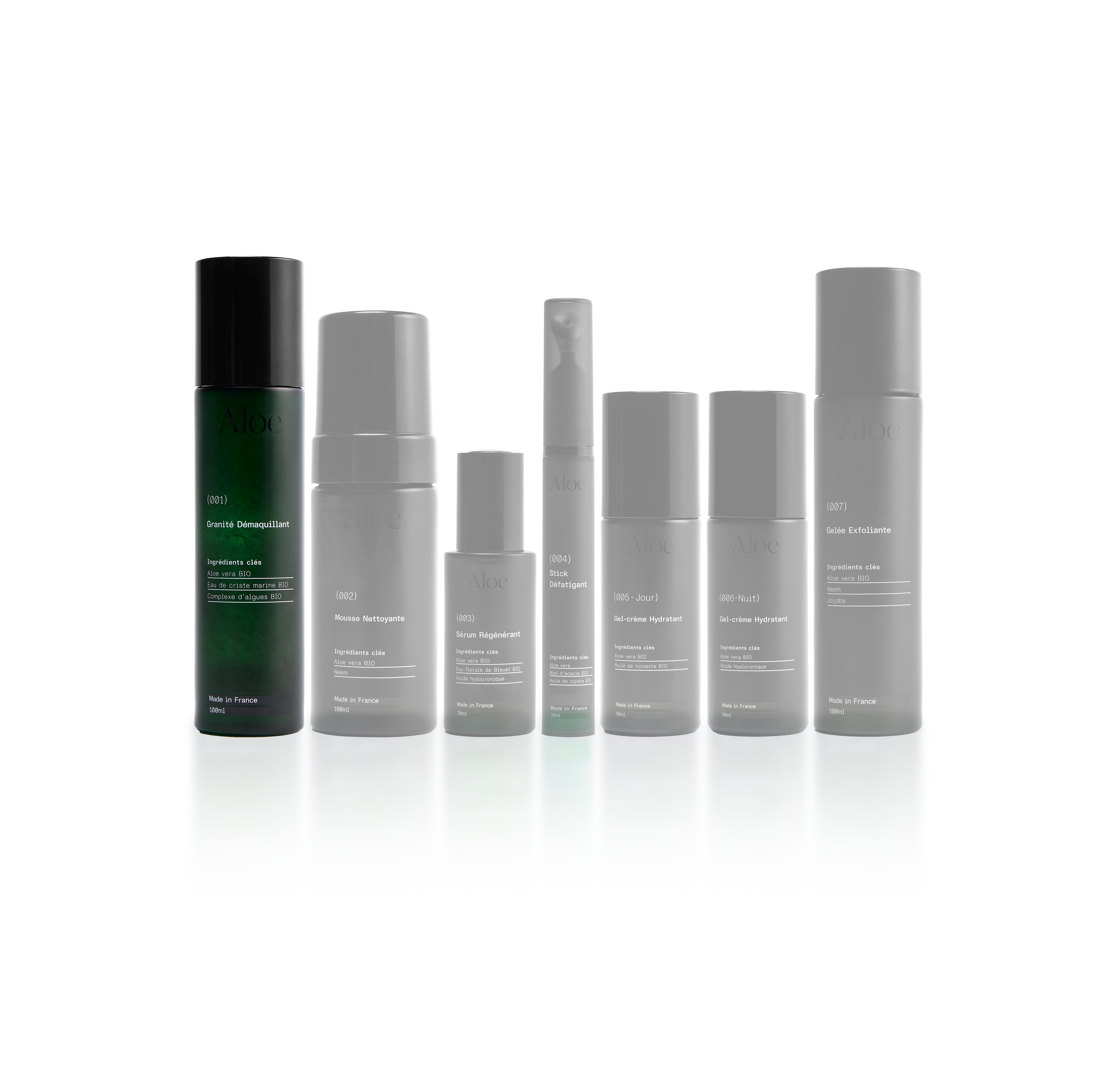 Seven skincare product bottles arranged in a row on a reflective surface.