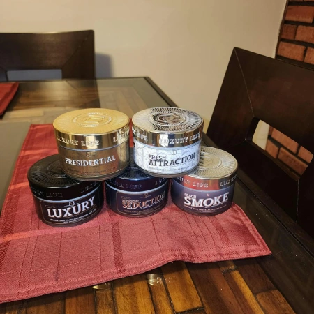 Five different scented air freshener jars from Luxury Life arranged on a red placemat on a table.