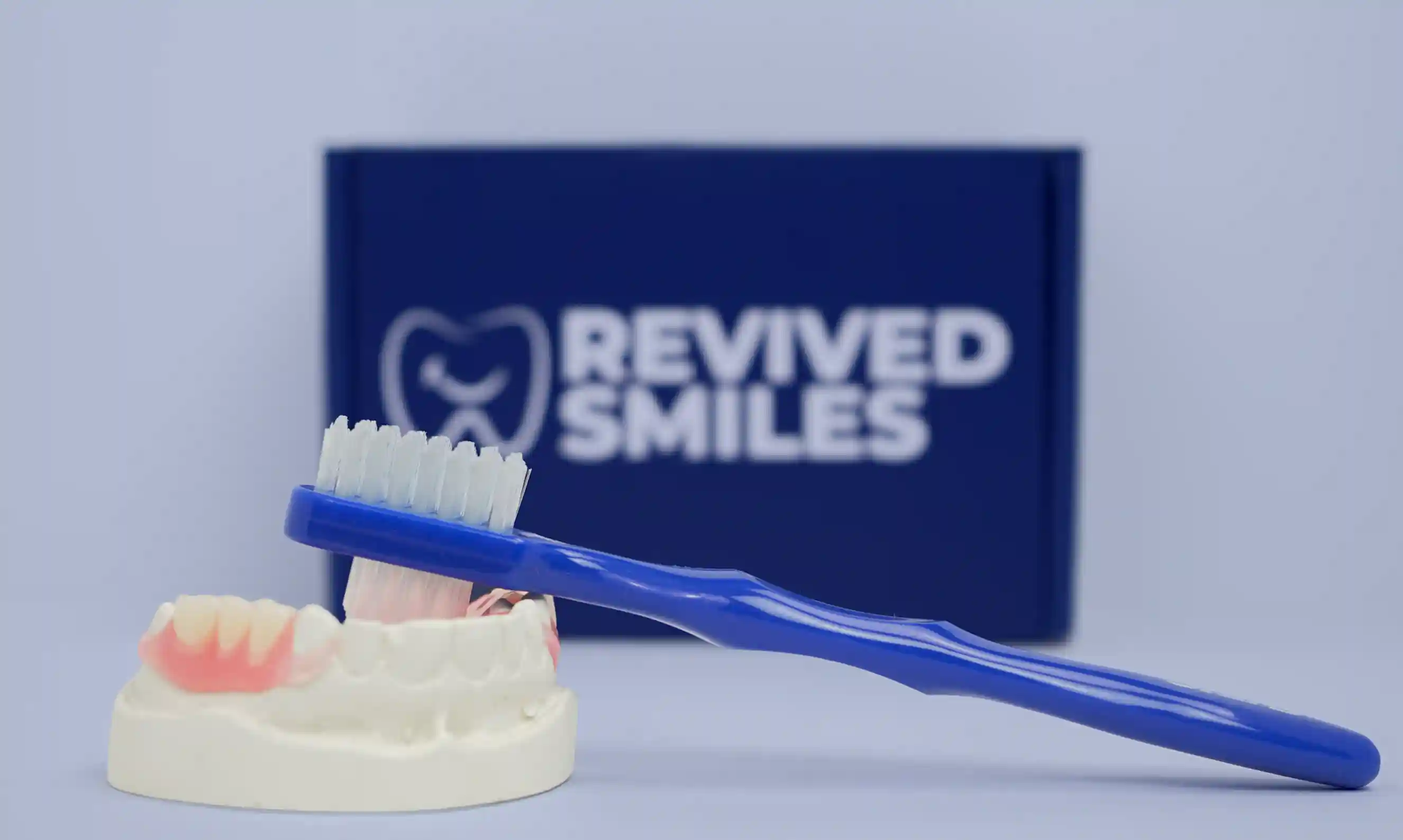 Toothbrush laying on top of a Stone model with a flexible partial denture fitted on the model