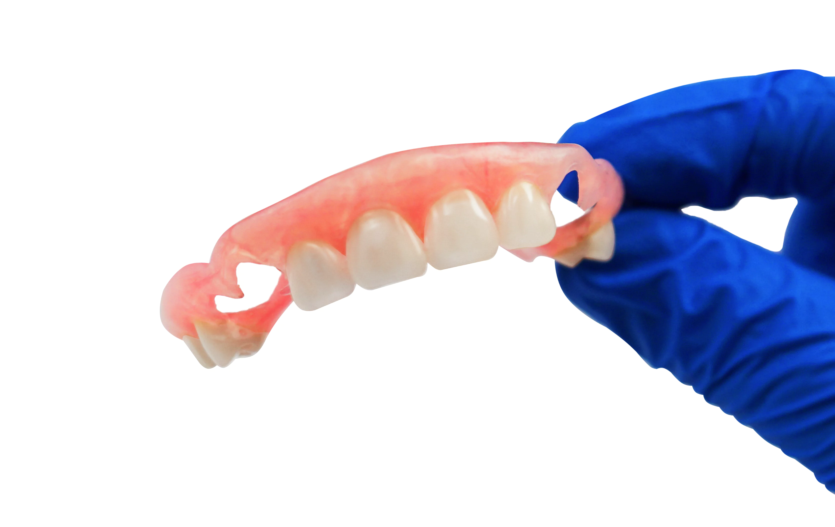 A gloved hand holding a partial denture with pink gums and white teeth.