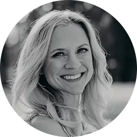 Black and white photo of a smiling person with long hair.