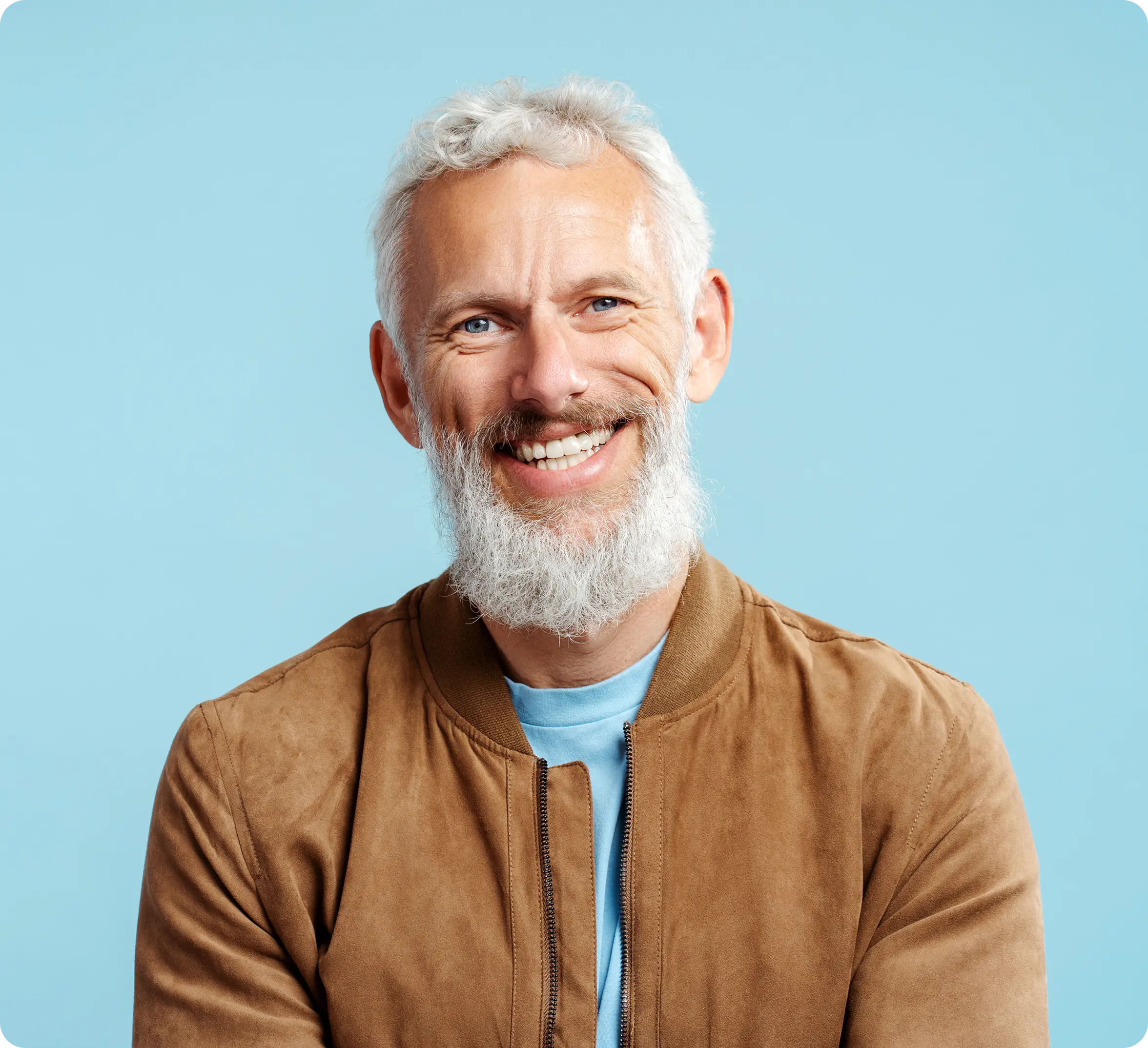 Smiling man with a beard wearing a brown jacket against a blue background.