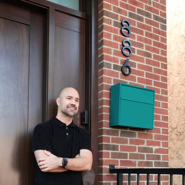 Adam, Founder of Adoorn, with a wall mount mailbox