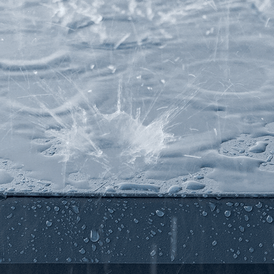 Raindrops splashing on a wet surface, creating ripples and droplets.