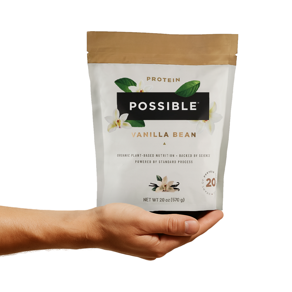 Hand holding a vanilla bean protein powder package labeled 'Possible.'