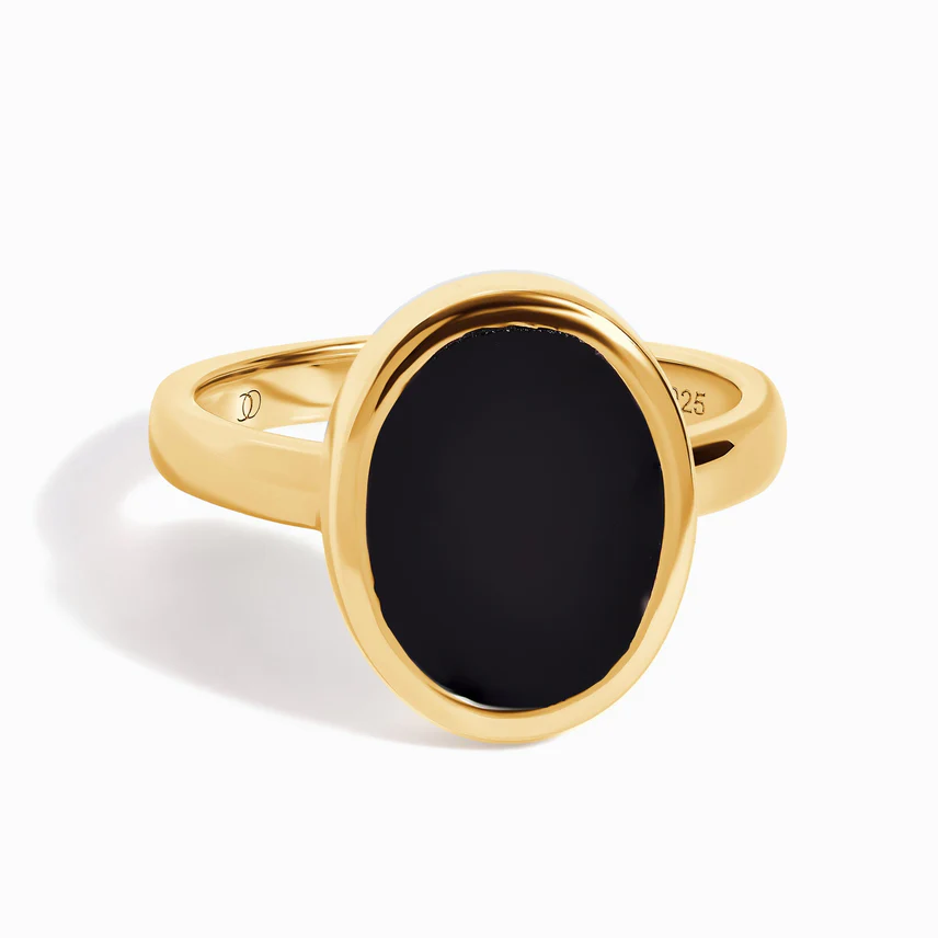 Gold ring with a large black oval stone on a white background.