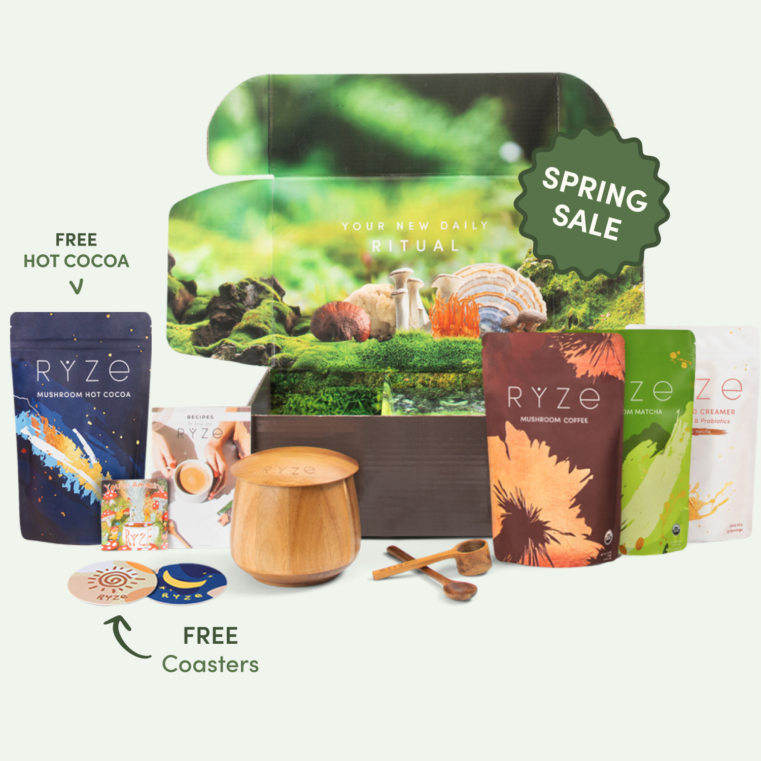 Assorted Ryze products including mushroom matcha, hot cocoa, coasters, and wooden spoons with a spring sale label.