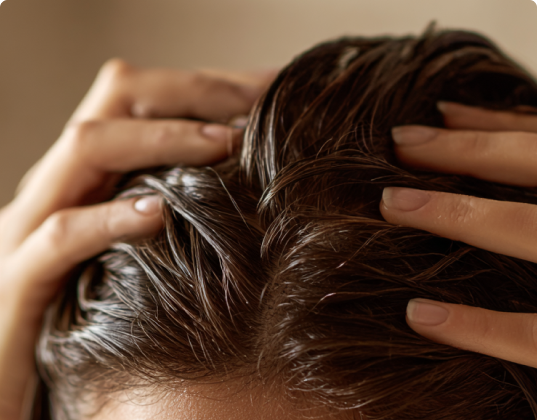 Hands massaging scalp with wet hair.