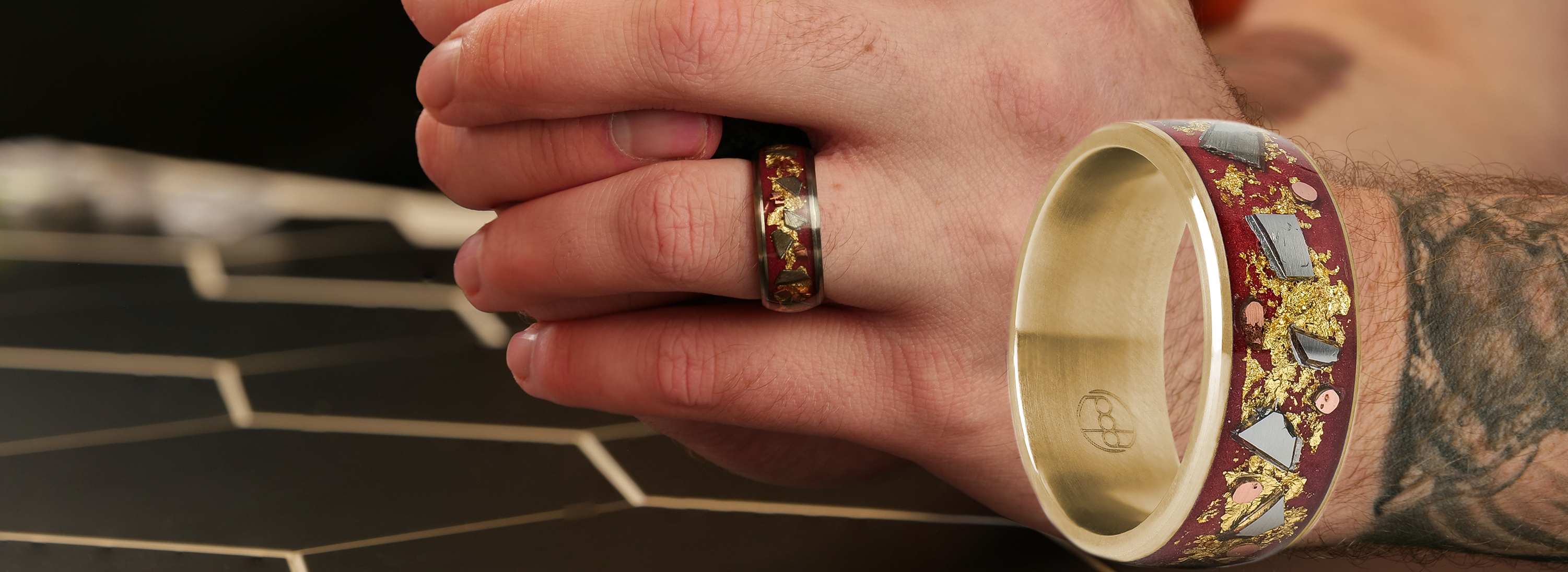 A man wearing a ring with red inlay and gold flakes, alongside a close-up of the same ring.