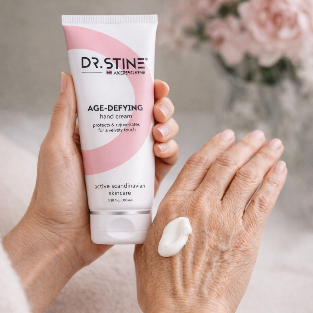 A person holds a tube of Dr. Stine hand cream with a dollop of it on their hand.