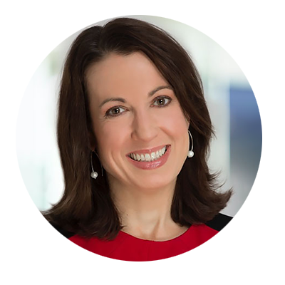 Smiling woman with brown hair wearing a red top and earrings.