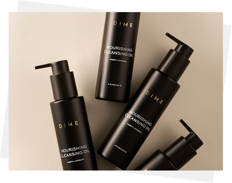 Four black bottles of Dime Nourishing Cleansing Oil on a beige background.