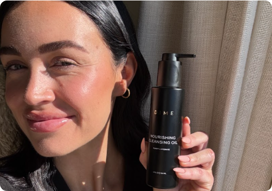 Person holding a bottle of DIME Nourishing Cleansing Oil.