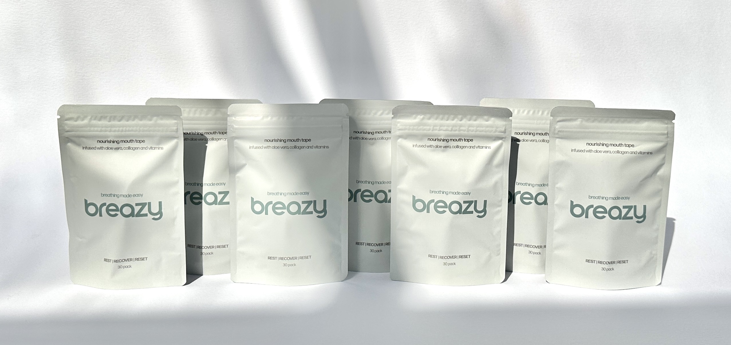 Several white packages labeled 'breazy' with text about nourishing mouth tape.