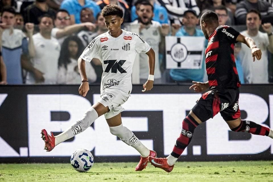 Two soccer players in action during a match, with a crowd in the background.