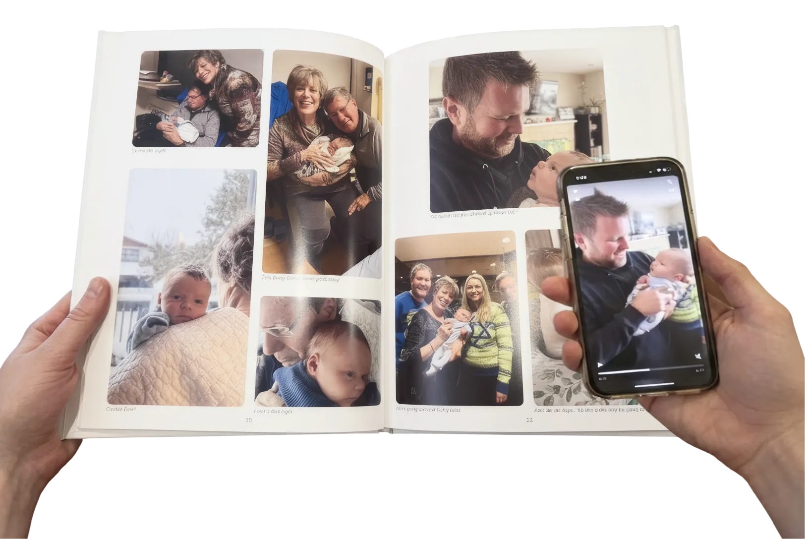 A person holds open a photo album and a phone which is playing a video of a baby.