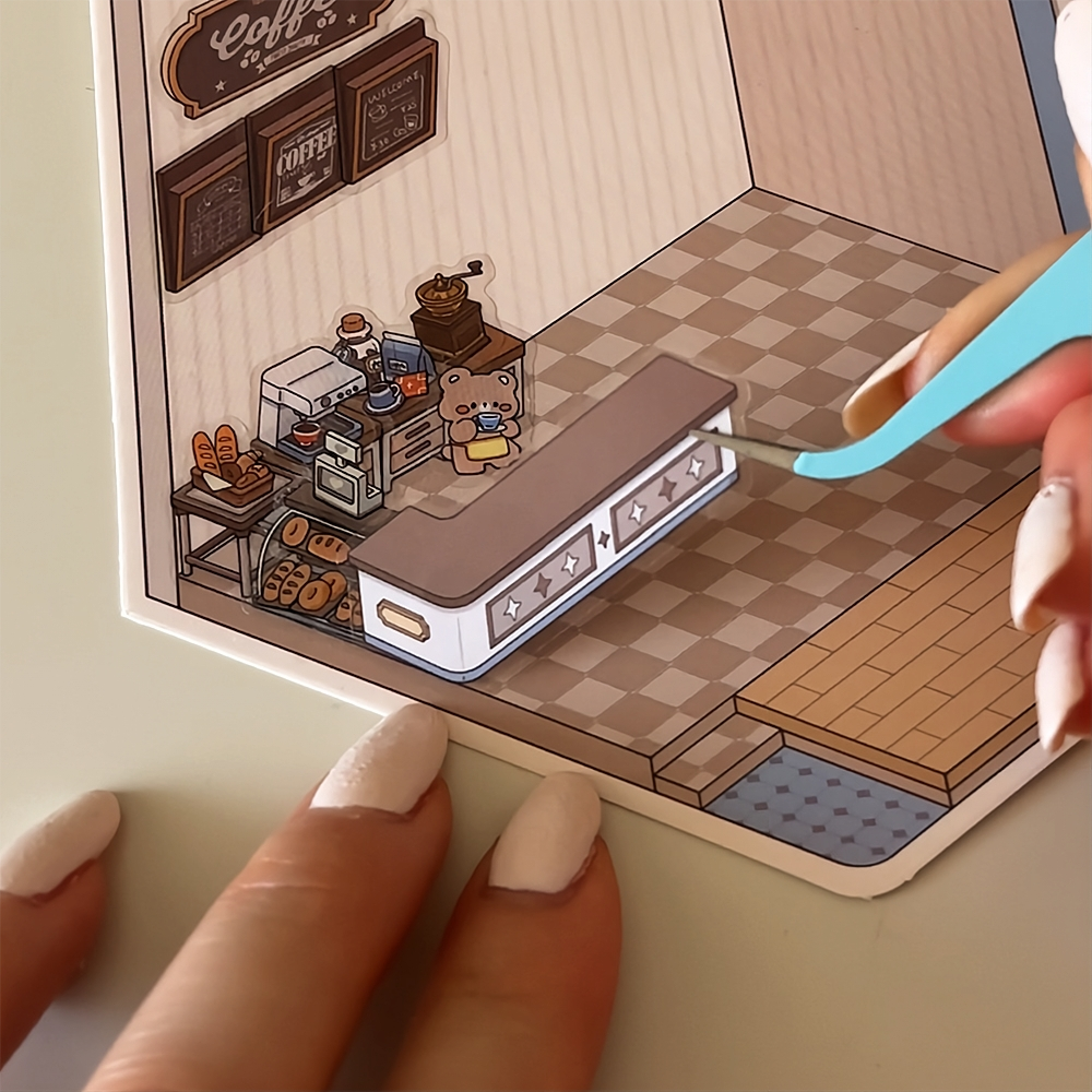 Miniature coffee shop diorama with a bear figure and bakery items.