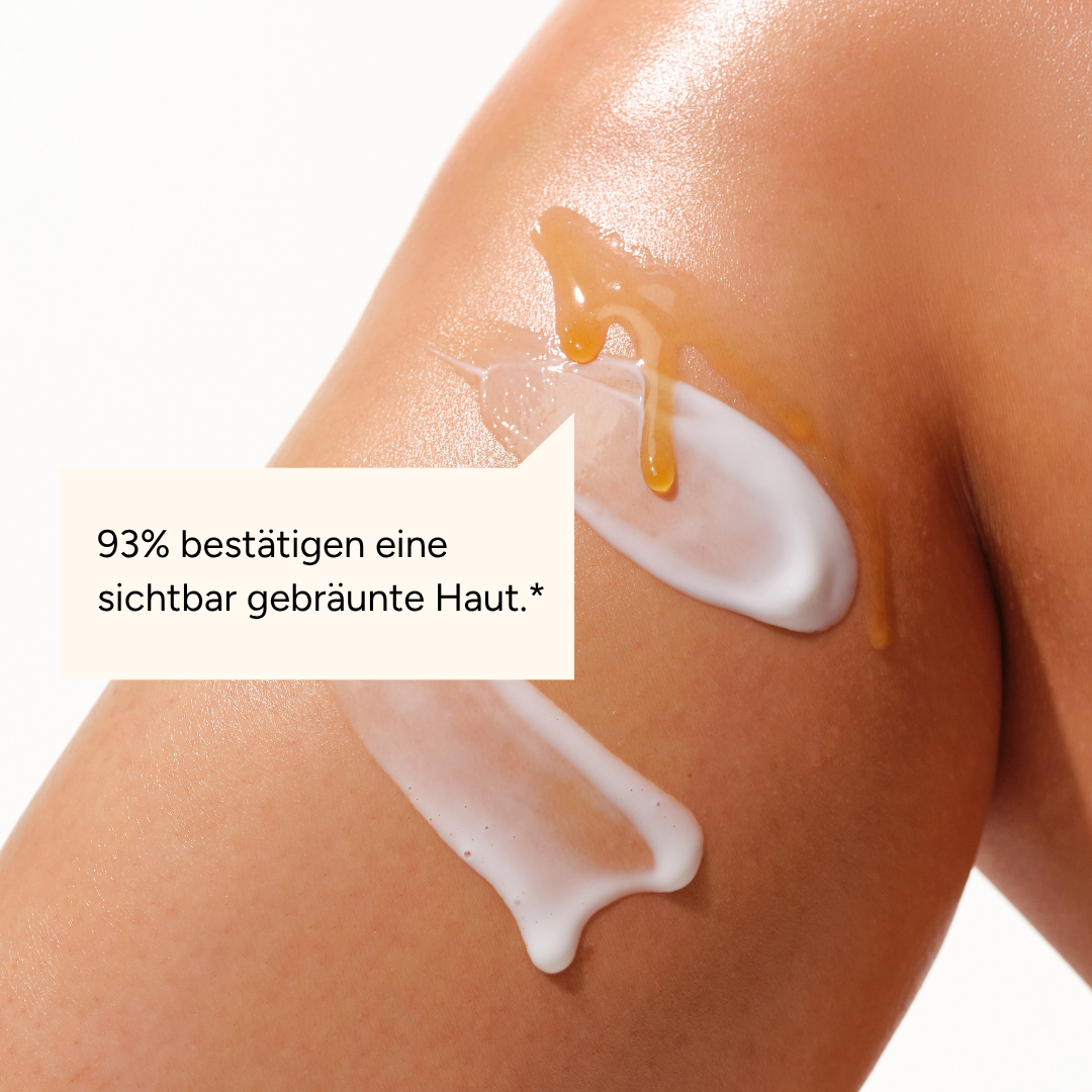 A close-up of tanned skin with smears of white lotion and golden gel on it.