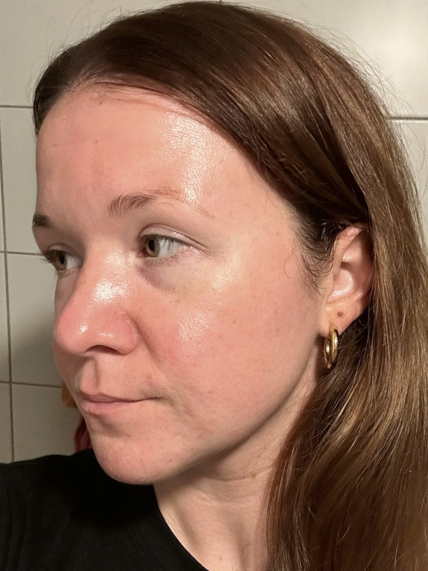 A close-up profile view of a woman with light brown hair and a gold hoop earring.
