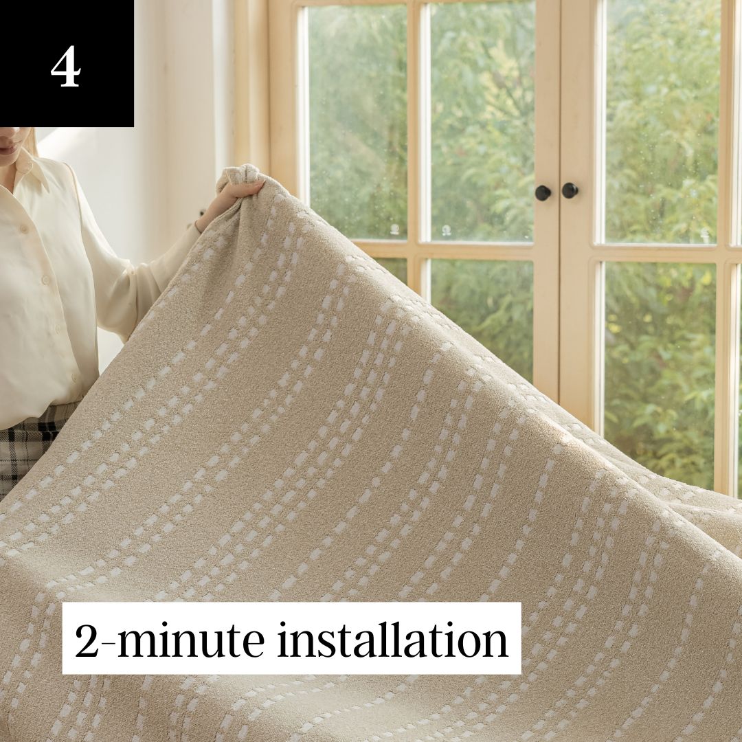 Person holding a patterned blanket near a window.