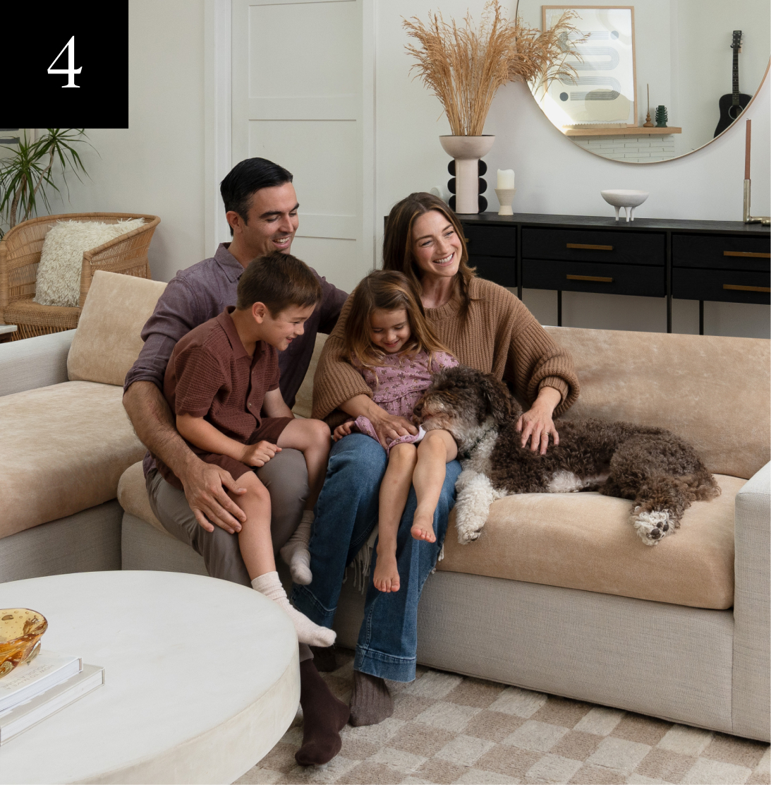 Family sitting on a couch with a dog, smiling and relaxed.