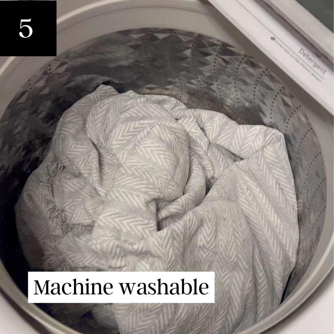 A close-up shot of a gray and white patterned blanket inside a top-load washing machine drum.