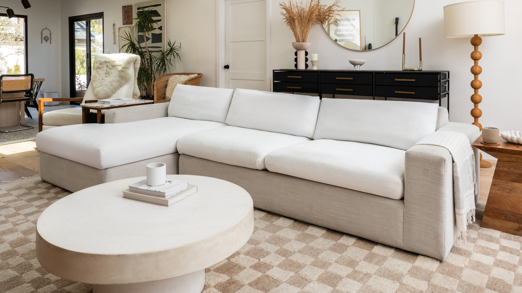 Modern living room with beige sofa and round coffee table.