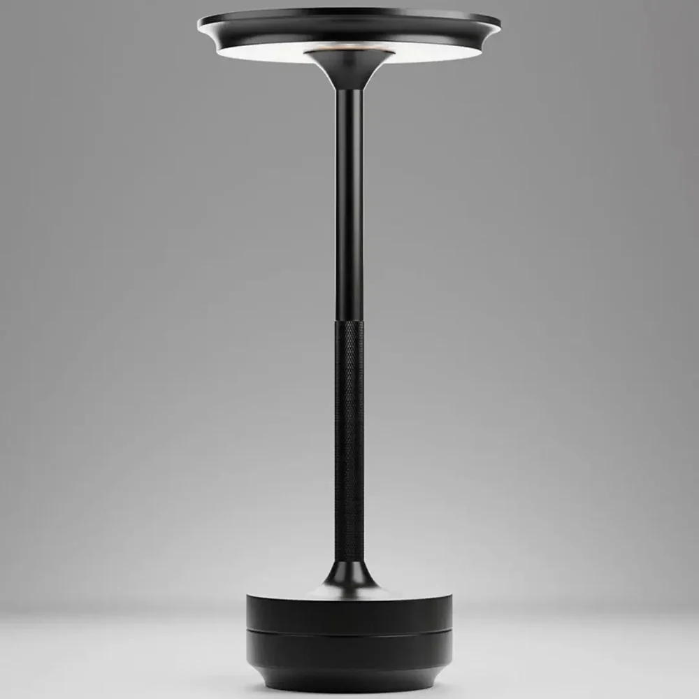 A modern, minimalist black table lamp with a tall stem, round base, and a flat, circular light source.