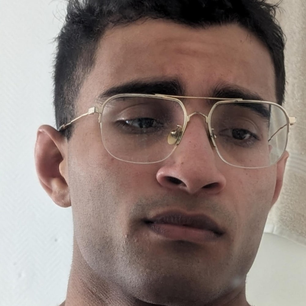 Close-up of a person wearing glasses with a neutral expression.