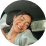 Person smiling inside a car with blurred background.