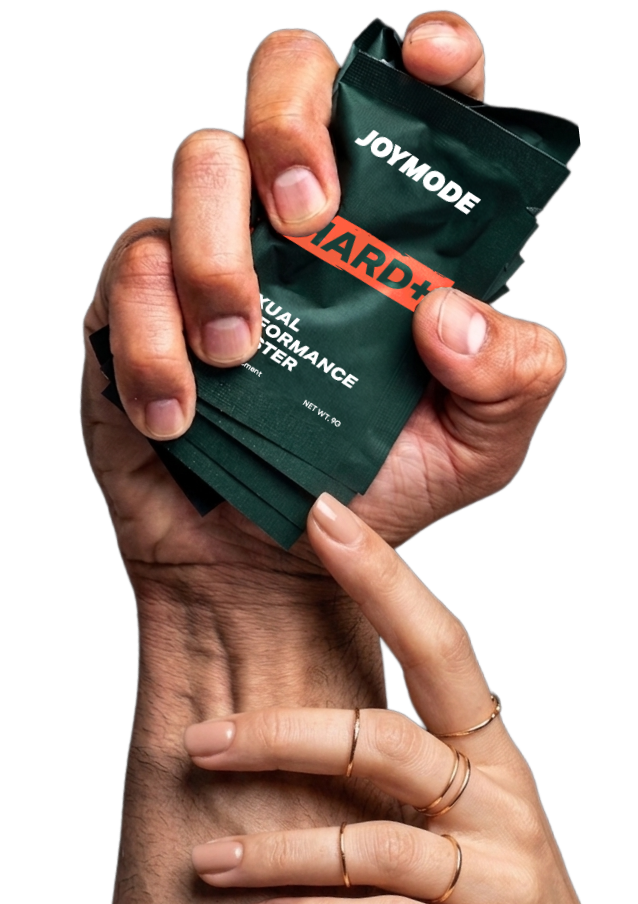 A man's hand holding several green Joymode packets as a woman's hand rests on his wrist.
