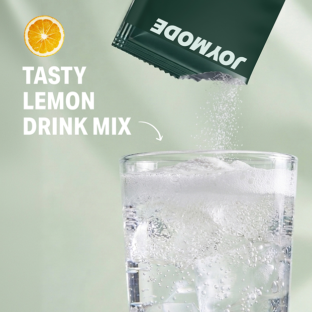 A packet of Joymode lemon drink mix being poured into a glass of sparkling water with ice.