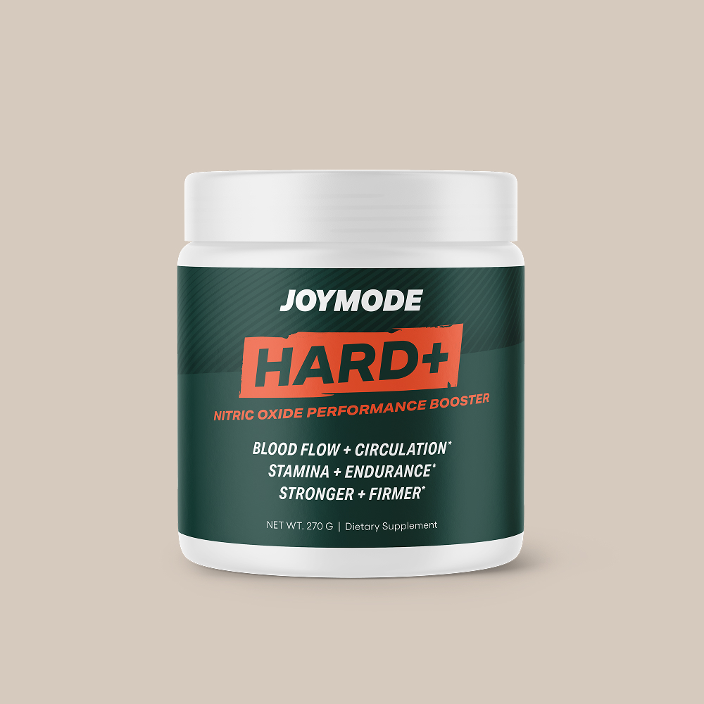 A white jar of Joymode Hard+ Nitric Oxide Performance Booster dietary supplement against a light brown background.