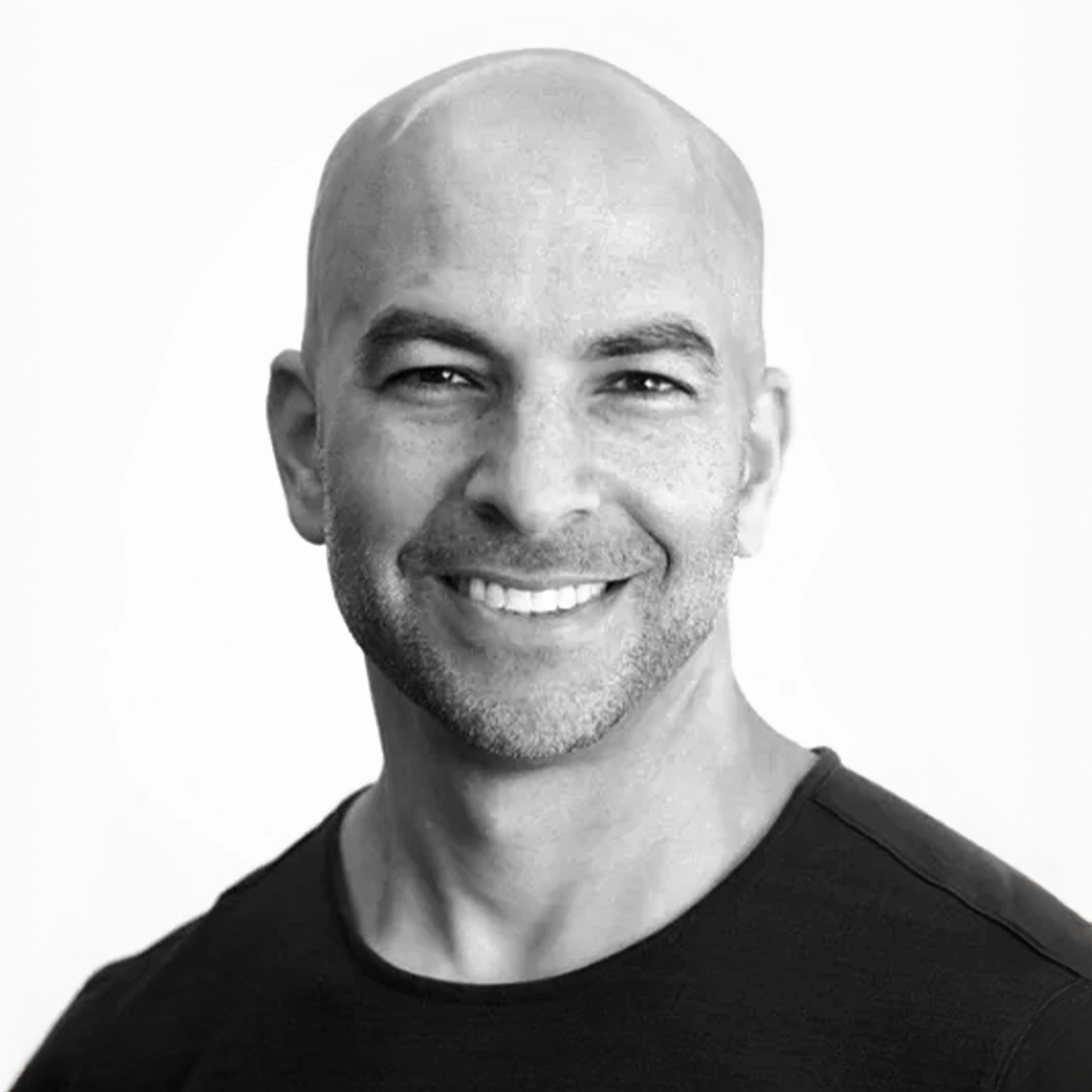 Smiling bald man in a black shirt against a white background.