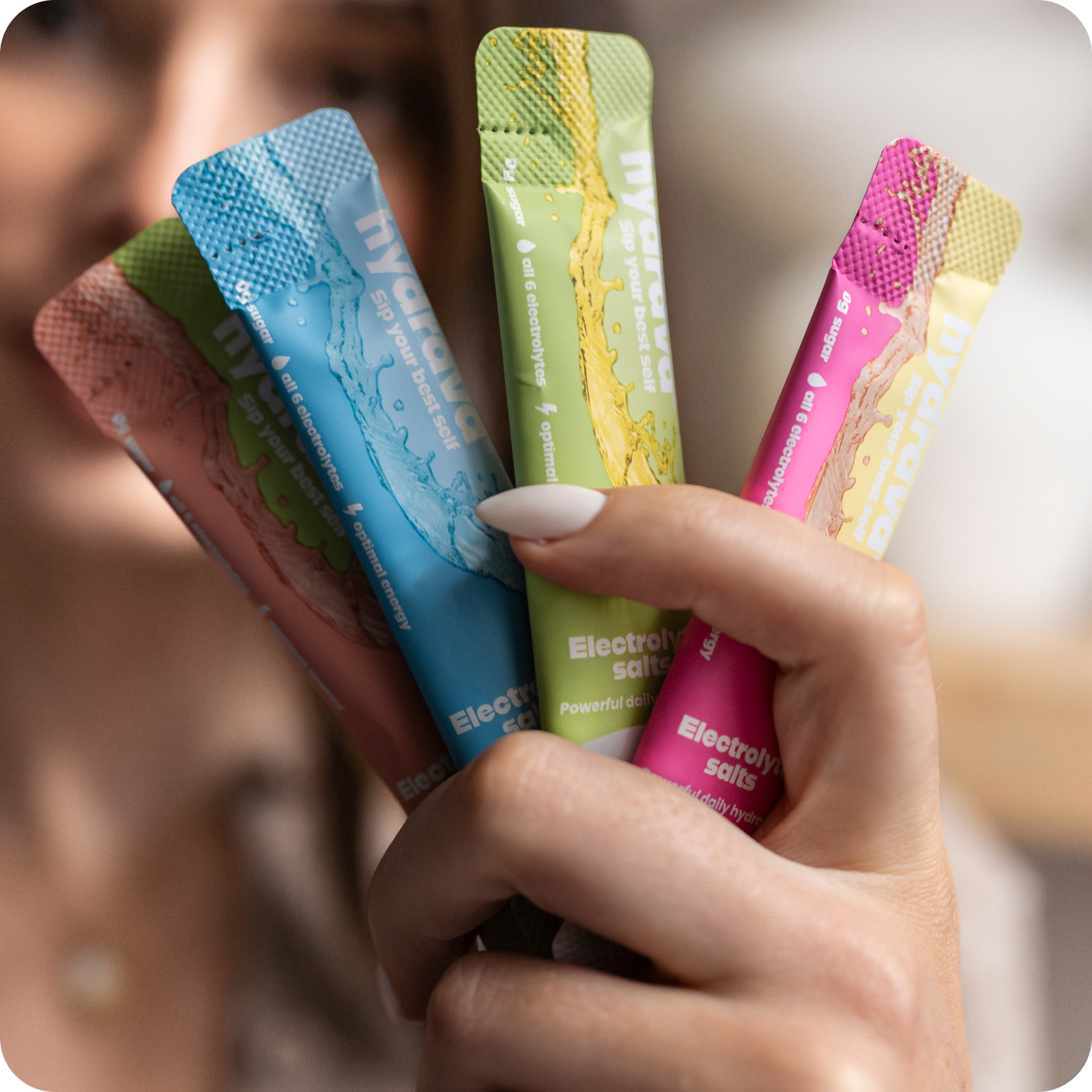 Hand holding colorful electrolyte gel packets.