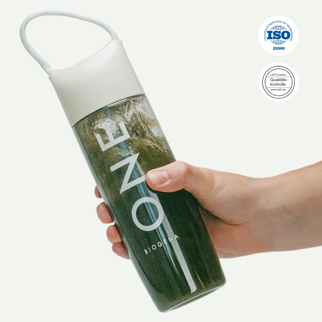 Hand holding a bottle labeled 'ONE' with a white cap and strap.