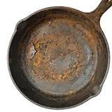 An old cast-iron skillet covered in rust, viewed from above against a white background.