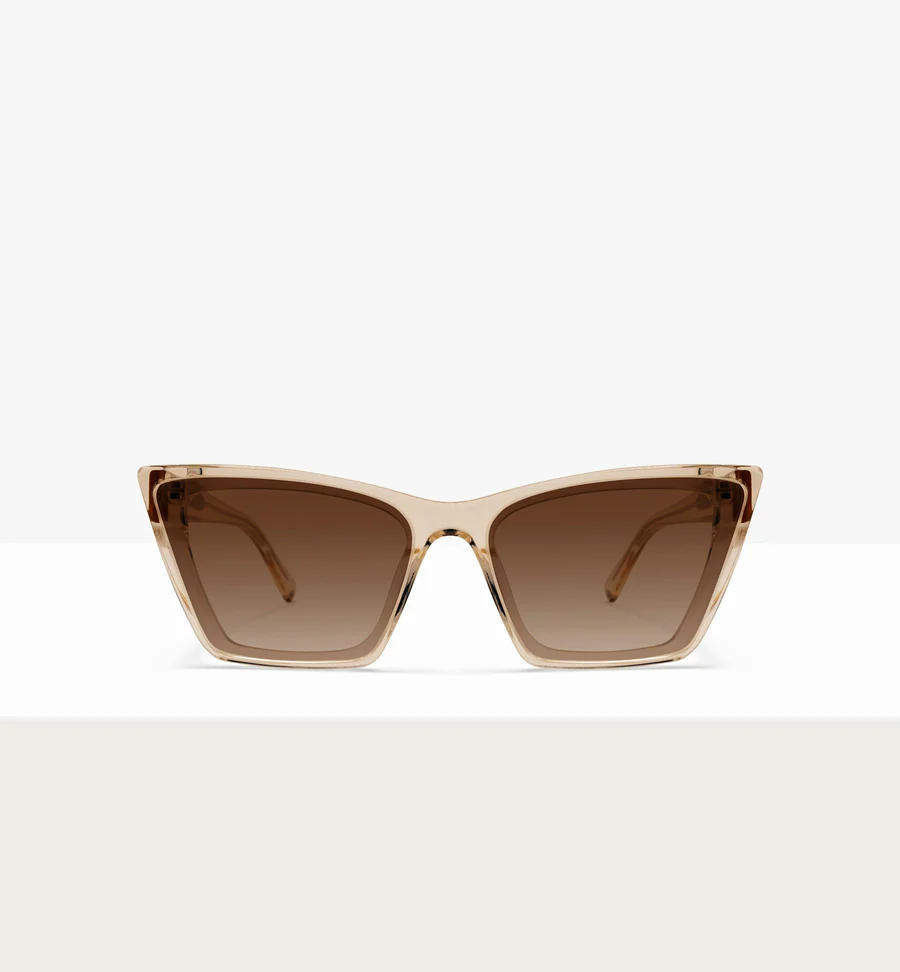 A pair of angular, translucent beige sunglasses with brown gradient lenses, shot against a white background.