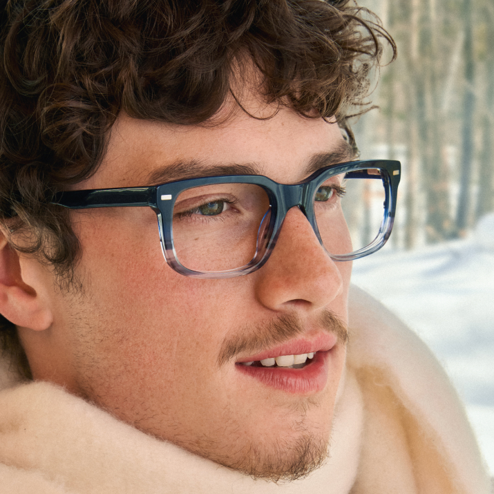 Person wearing glasses with a snowy background.