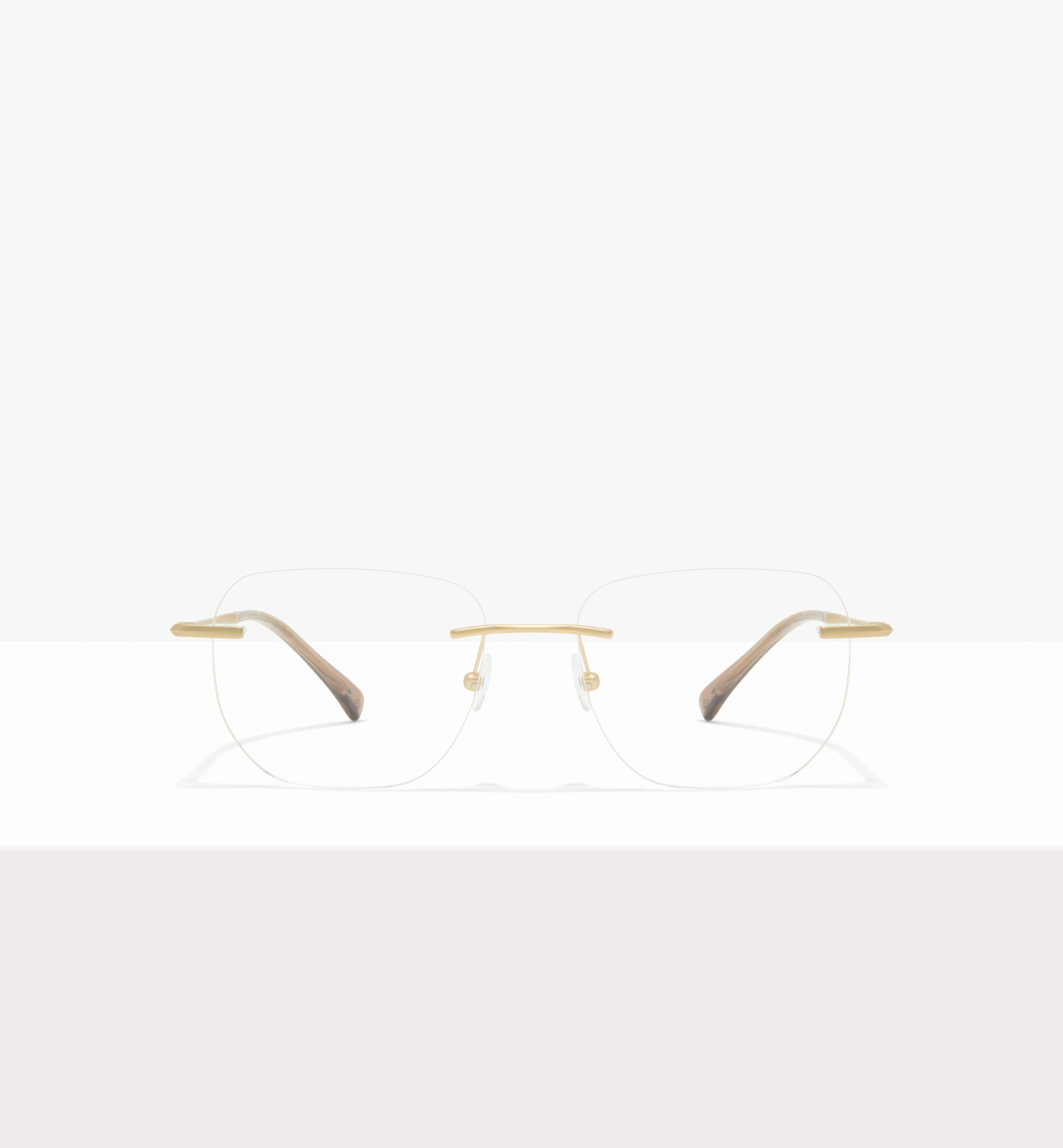 Minimalist eyeglasses with gold bridge and temples on a white background.