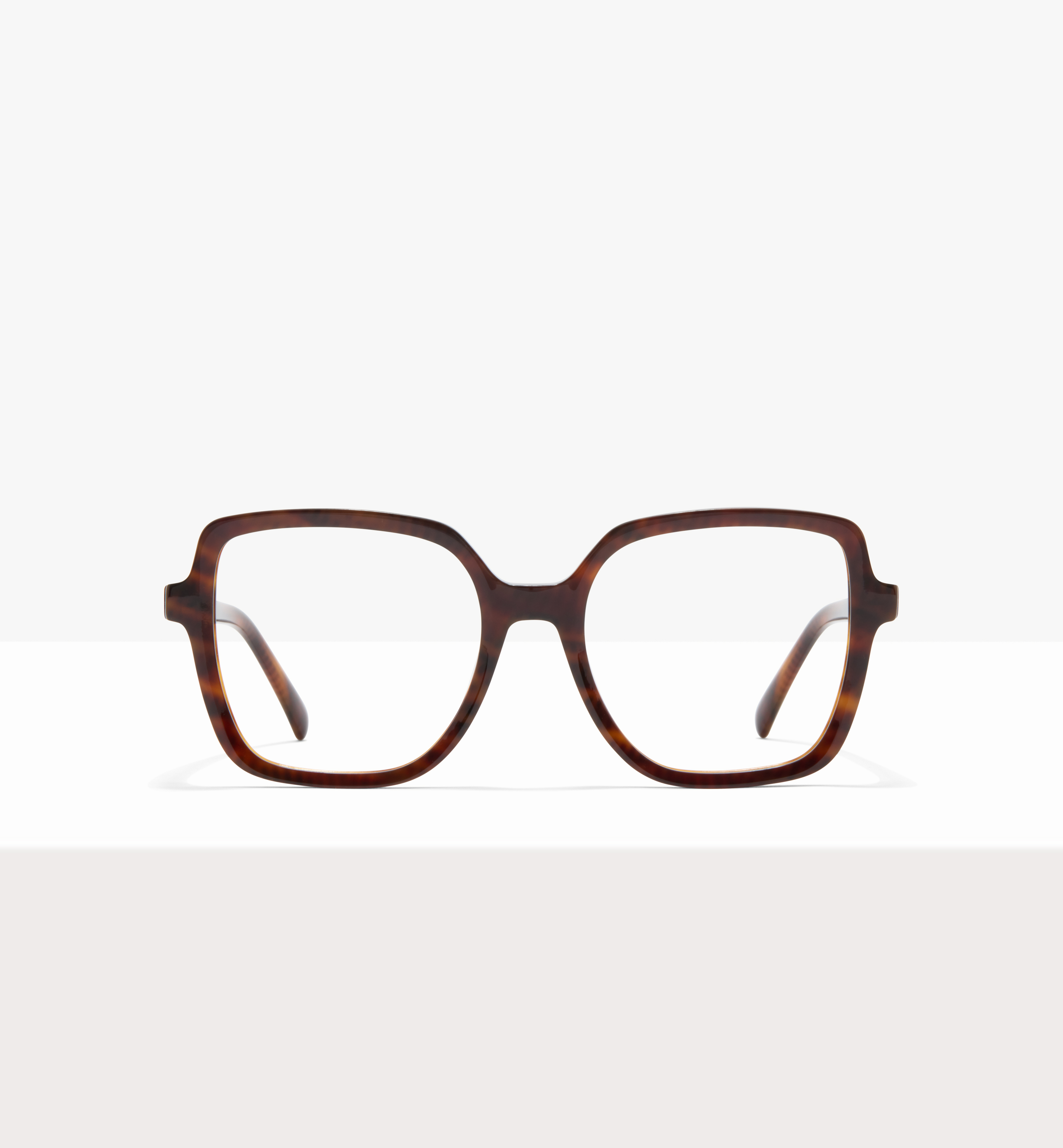 Une paire de grandes lunettes Carrées avec un motif écaille de tortue, posée sur une surface blanche.