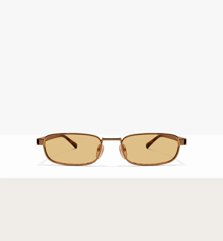 A pair of rectangular sunglasses with thin gold-colored frames and amber-tinted lenses on a white background.