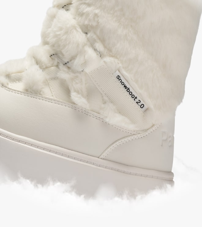Close-up van een witte sneeuwlaars met bontvoering met het label 'Snowboot 2.0'.