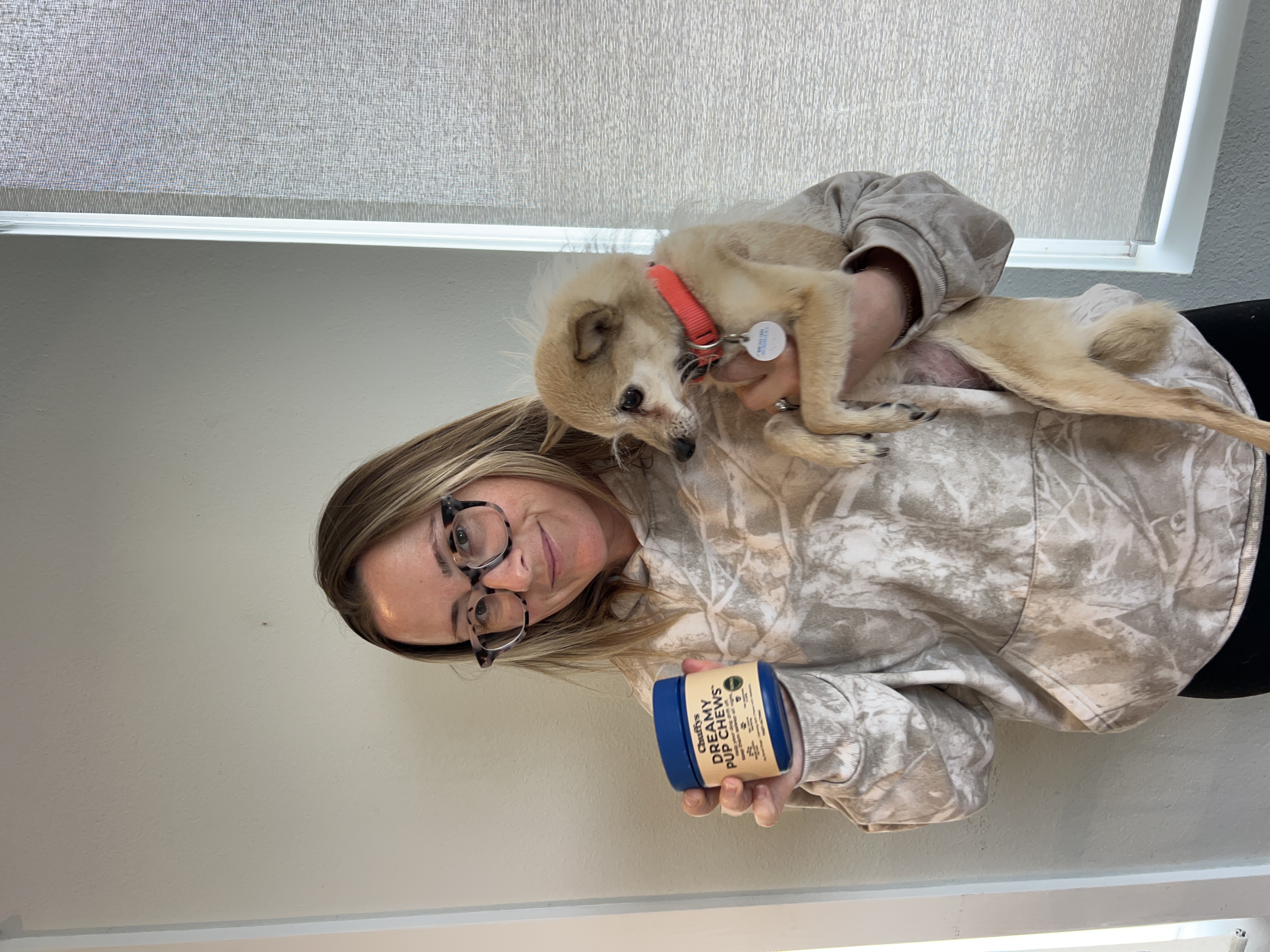 Veterinarian holding a husky puppy and a container of dog treats.