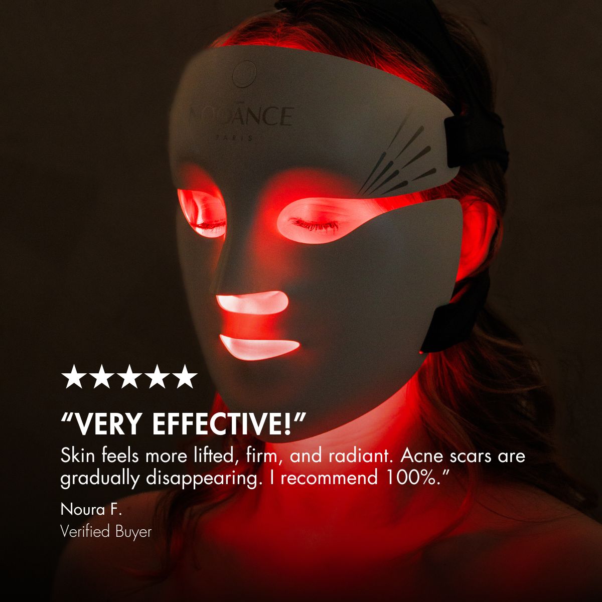 A person wearing an illuminated LED face mask for skincare.