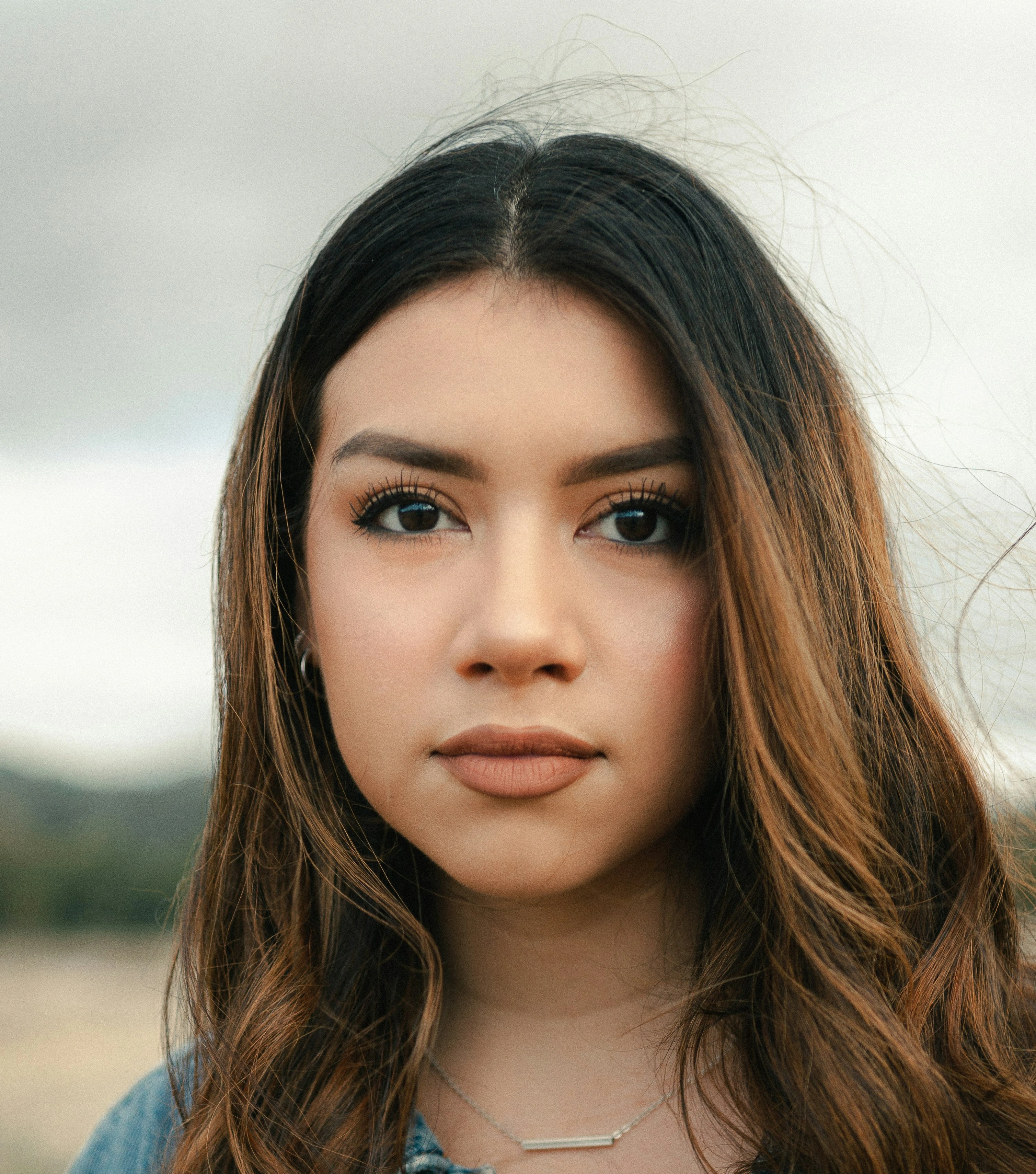 A person with long brown hair looking directly at the camera.
