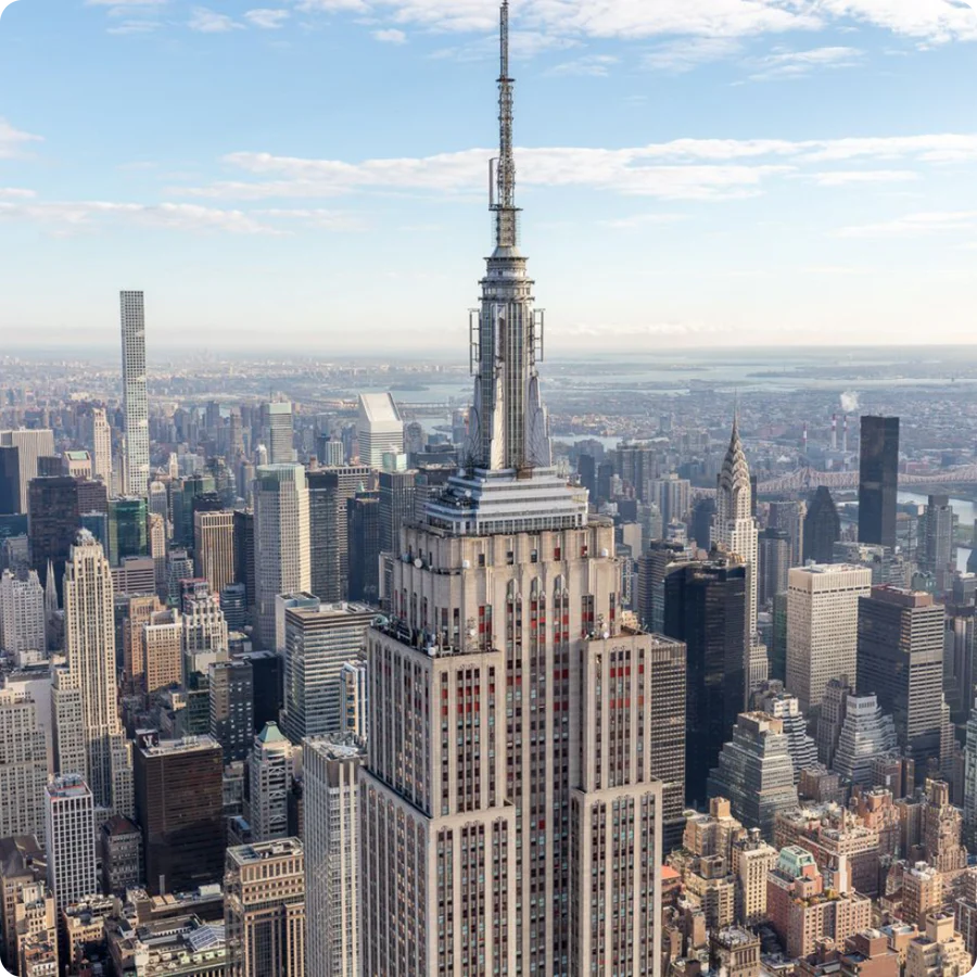 Aerial view of a city skyline with a prominent skyscraper in the foreground.