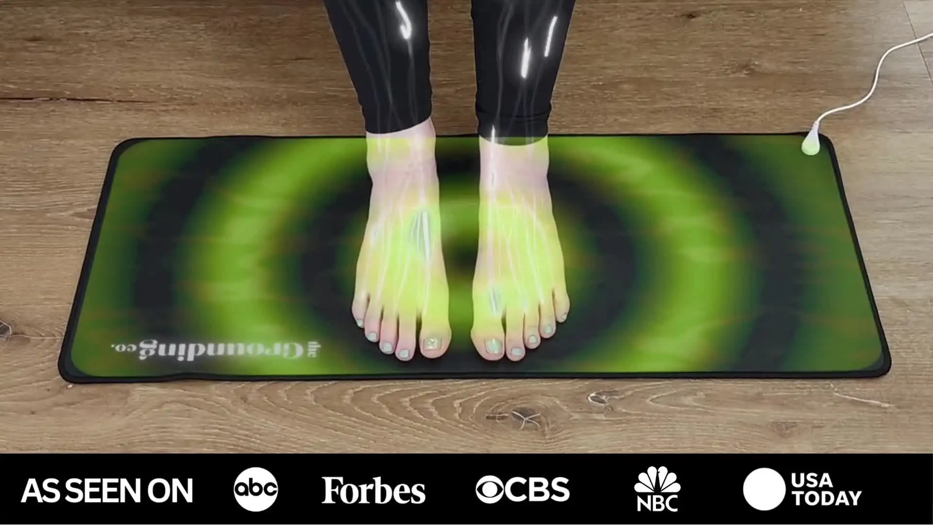 Feet on a glowing green mat with media logos below.